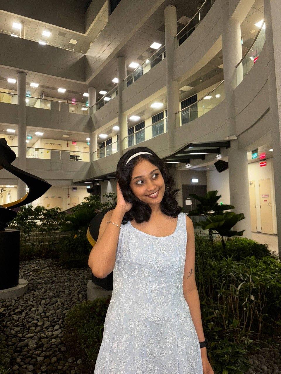 Esha Nakka smiling in a light blue floral dress